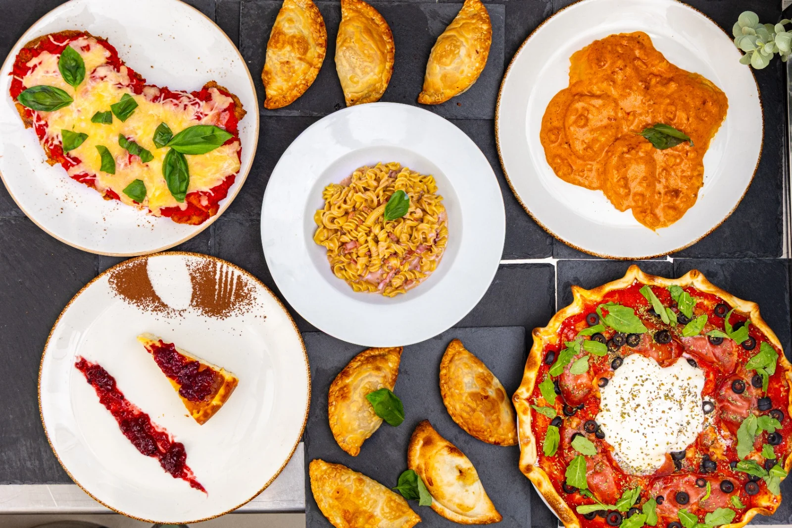 Mesa completa con selección de pastas, pizzas y empanadas artesanales